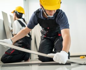 Asian Craftsman worker man and woman work by installs laminate board on floor to renovating house.
